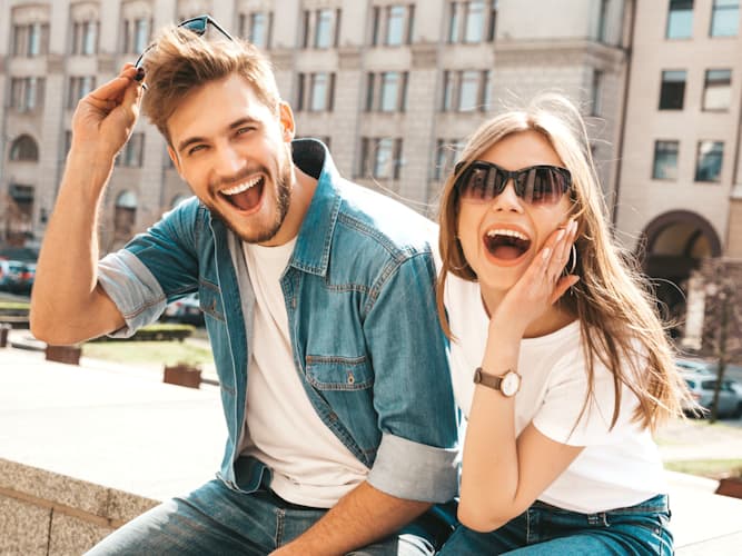 young man and woman couple are very happy sitting outside